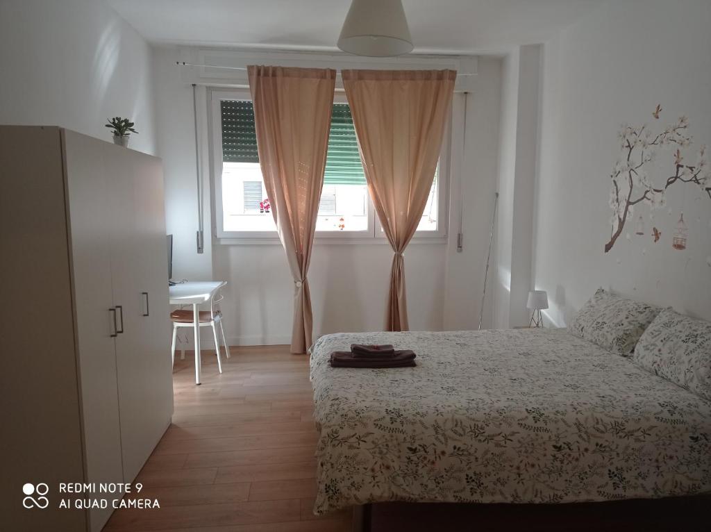 Schlafzimmer mit einem Bett, einem Fenster und einem Tisch in der Unterkunft NICOLHOME in Rom