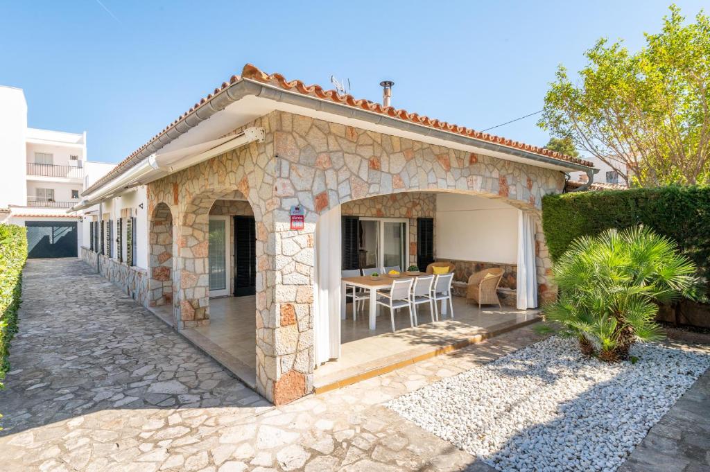 a stone house with a patio and a table at Villa Mercuri in Alcudia