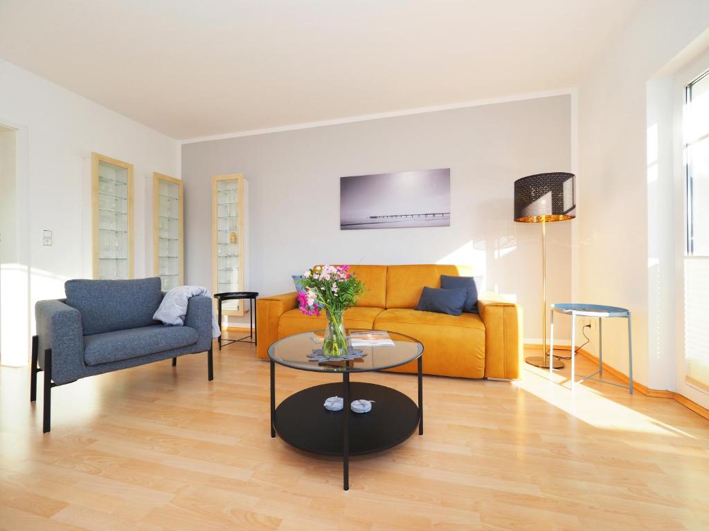 a living room with a yellow couch and a table at Ferienwohnung "Sonnenblick" in Ahlbeck