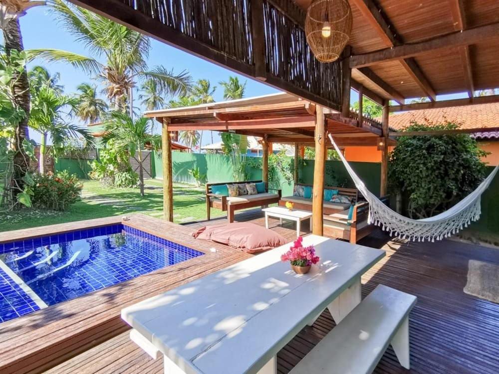 Un patio con hamaca y piscina. en La Villa Tropicale linda casa pertinho do mar !, en Icaraí