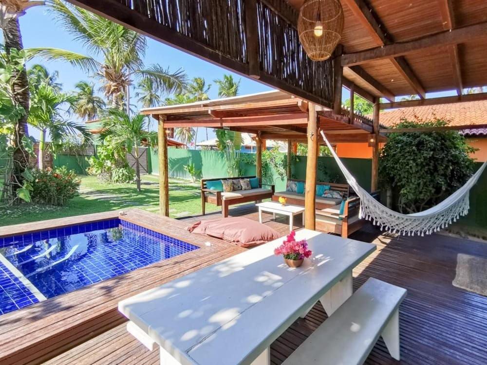 a patio with a hammock and a swimming pool at La Villa Tropicale linda casa pertinho do mar ! in Icaraí