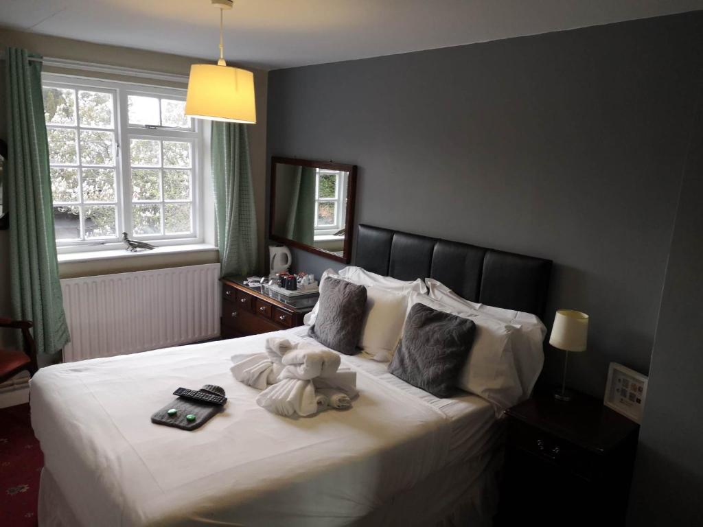 - une chambre avec un ours en peluche assis sur un lit dans l'établissement The Priory Hotel, à Louth