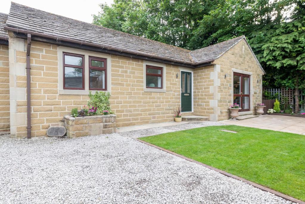 a small brick house with a lawn in front of it at The Croft by Nordstay in Steeton
