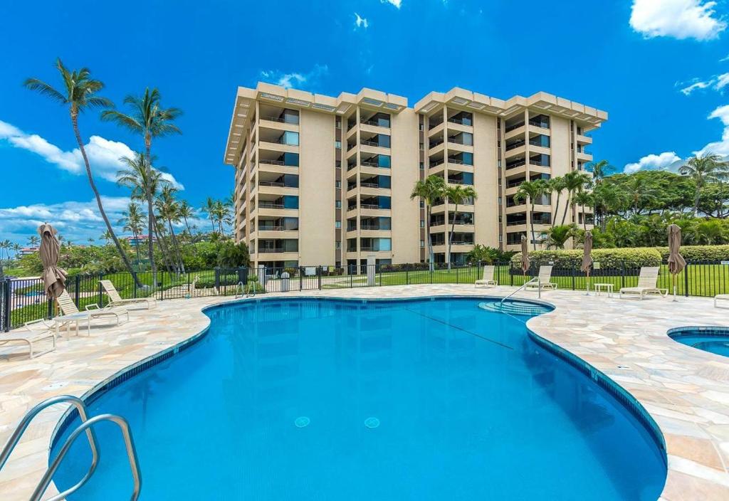 a swimming pool in front of a building at Polo Beach Club Two Bedrooms - Ground Floor by Coldwell Banker Island Vacations in Wailea
