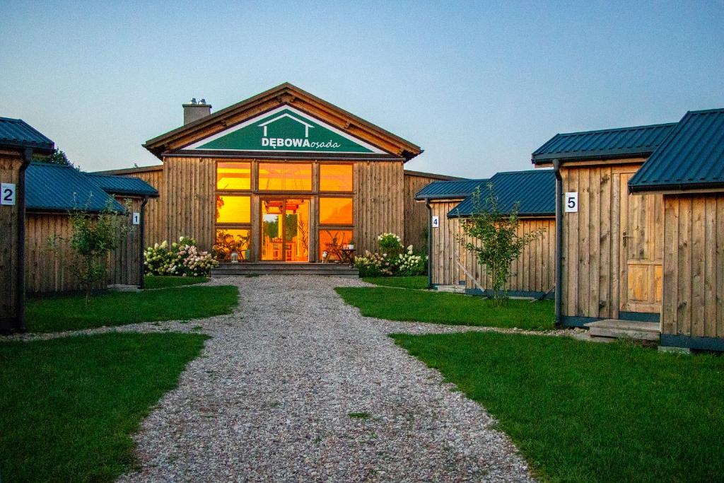 a barn house with a pathway leading to the entrance at Dębowa Osada in Bobolin