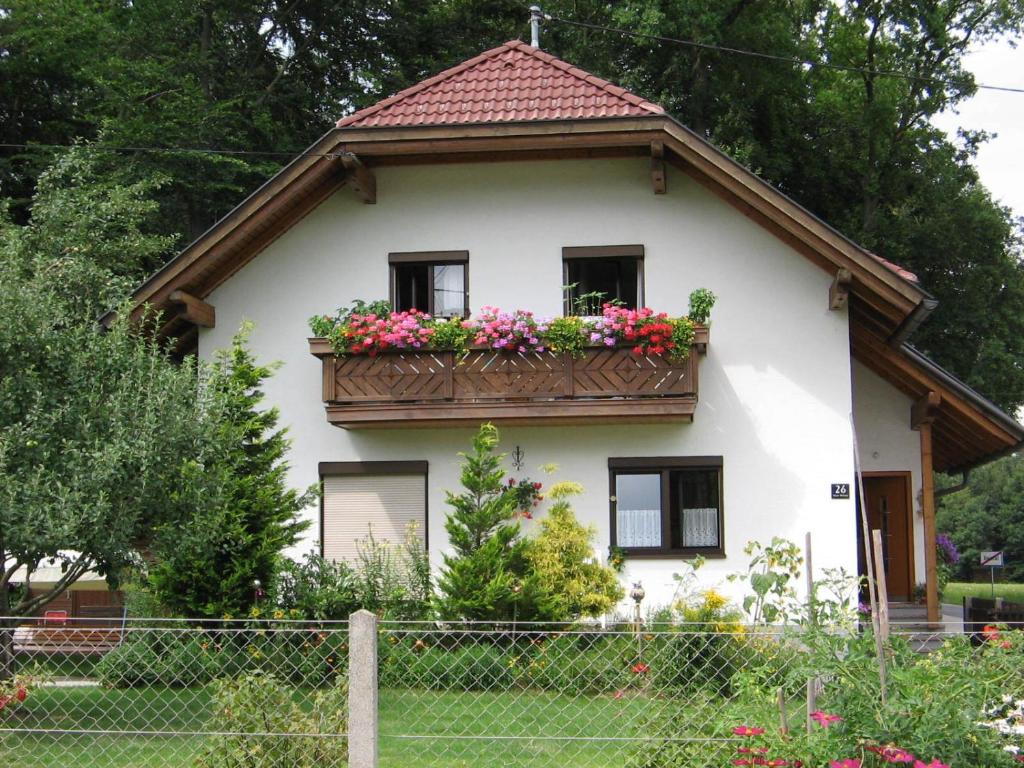 ein Haus mit einem Balkon mit Blumen darauf in der Unterkunft Maria's Ferienwohnung in Laakirchen