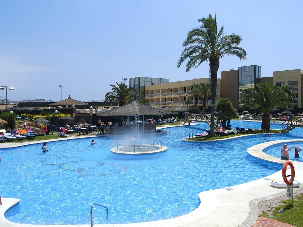 a large swimming pool with a fountain in a resort at Evenia Olympic Palace in Lloret de Mar