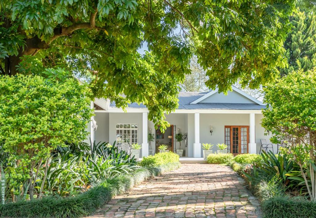 a white house with a brick driveway at Hopefield BnB in Addo