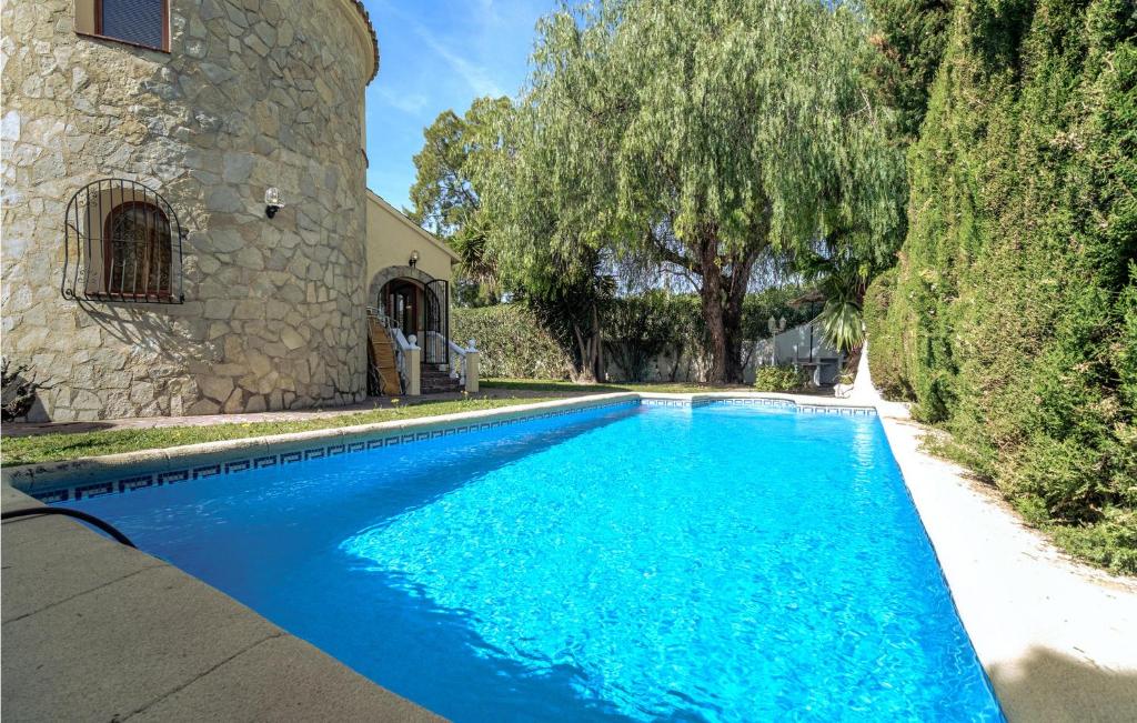 エルス・ポブレッツにあるAmazing Home In Els Poblets With 3 Bedrooms, Wifi And Outdoor Swimming Poolの家の前の青い水のプール