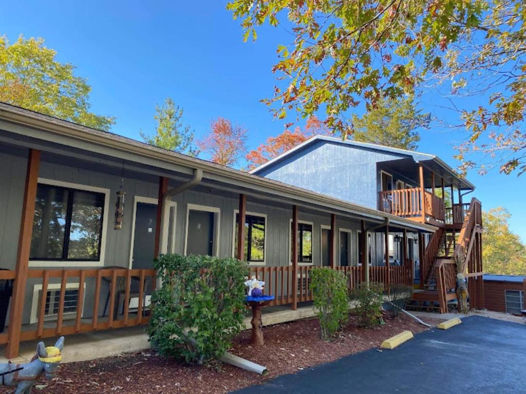 a home with a large porch and a deck at Shady Acre Inn and Suites in Branson West