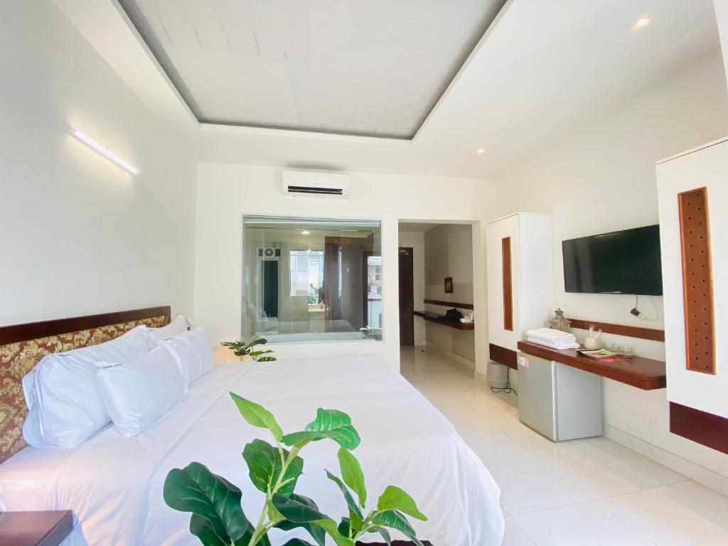 een slaapkamer met een wit bed en een televisie bij Gemini Saigon BOUTIQUE in Ho Chi Minh-stad
