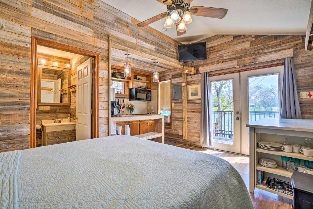 ein Schlafzimmer mit Holzwänden und ein Bett in einem Zimmer in der Unterkunft Guadalupe River Cottage with Direct Lake Access! in Seguin