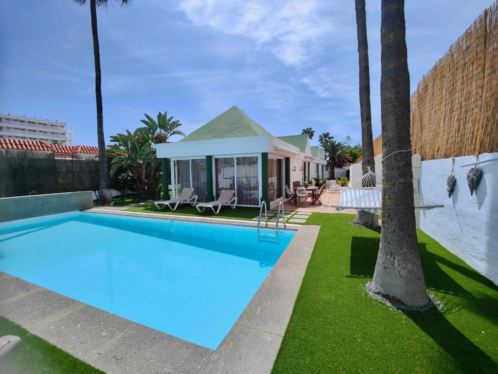 a swimming pool in front of a house at Villa Nuria con piscina privada in Playa del Ingles