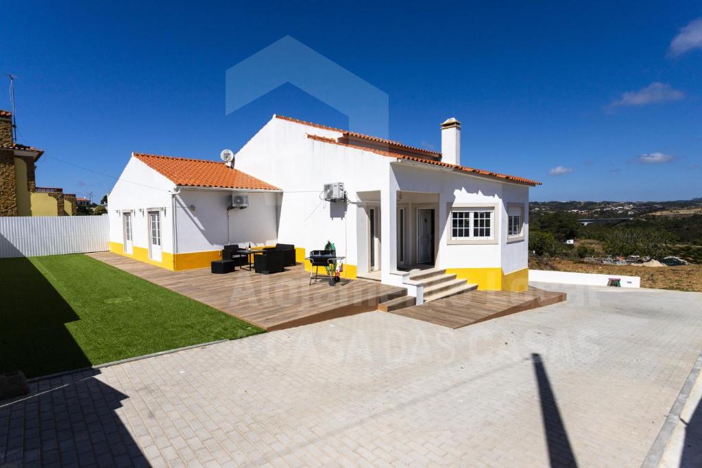 uma casa branca com um pátio em frente em Moinho D'ouro Residence by ACasaDasCasas na Ericeira