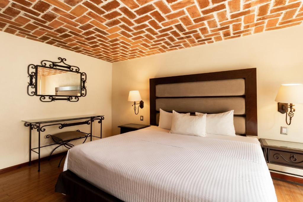 a bedroom with a bed and a brick ceiling at Hoteles Villa Mercedes San Cristobal in San Cristóbal de Las Casas