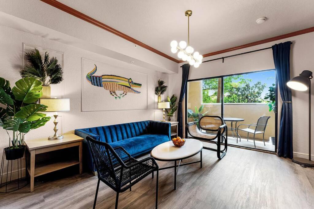 un soggiorno con divano blu e sedie di Designer Corner Suite 3br/2ba - Disney, Universal, Convention Center & SeaWorld a Orlando