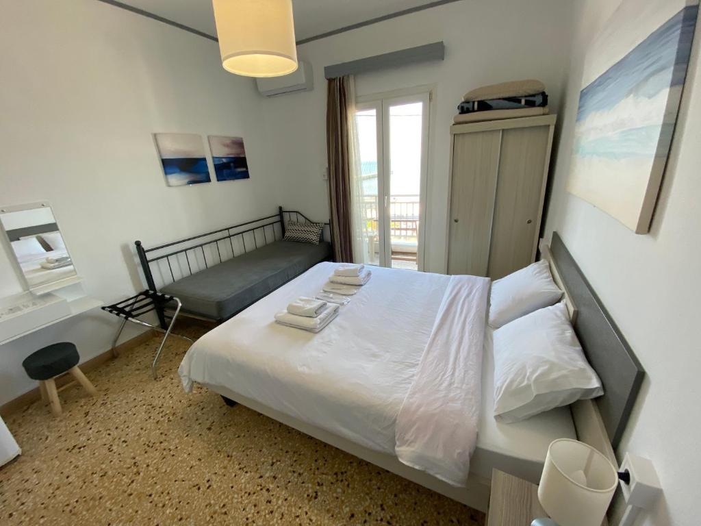 a bedroom with a bed and a chair and a window at Sunset view Rooms in Agia Triada