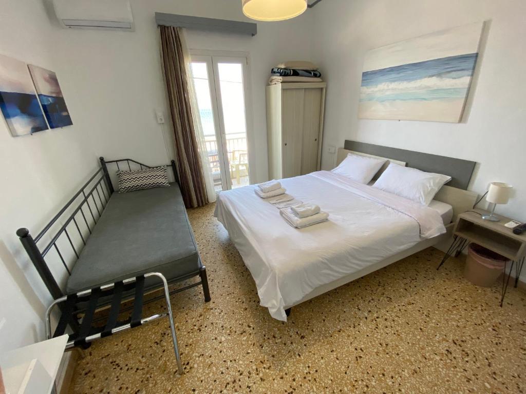 a bedroom with a bed and a bench in it at Sunset view Rooms in Agia Triada