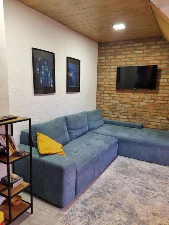 niebieską kanapę w salonie z telewizorem w obiekcie Apartament Nova Kamienica 2 w Łagowie