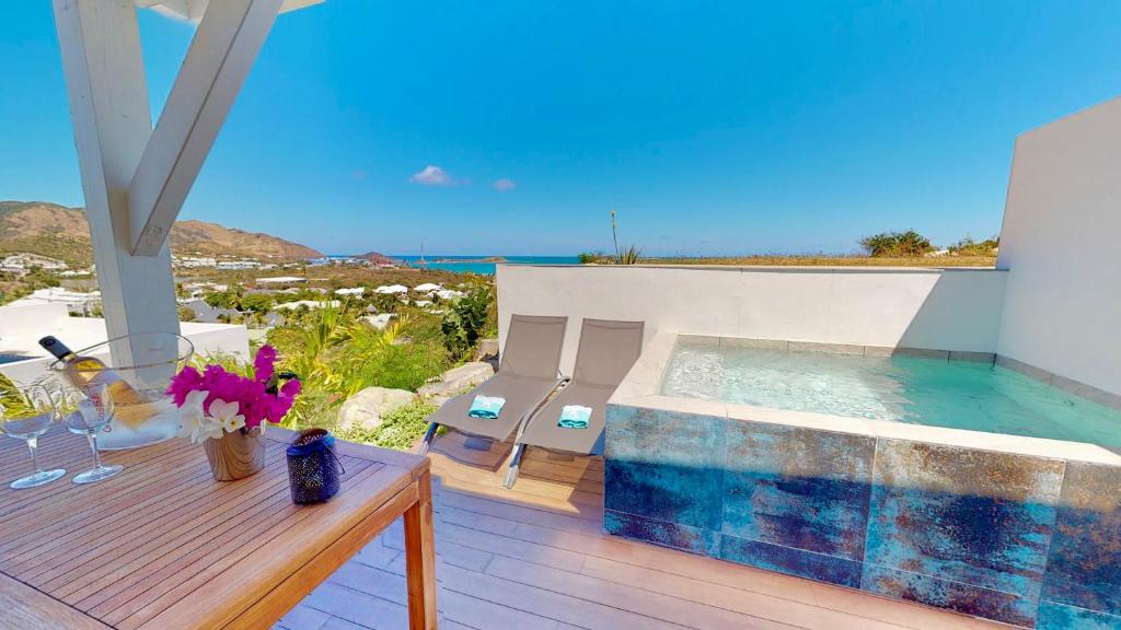 una piscina en una terraza con vistas al océano en SUNSEEKER SXM - Jardins Orient Bay - Appartement vue mer ou Studio vue Colline, en Saint Martin
