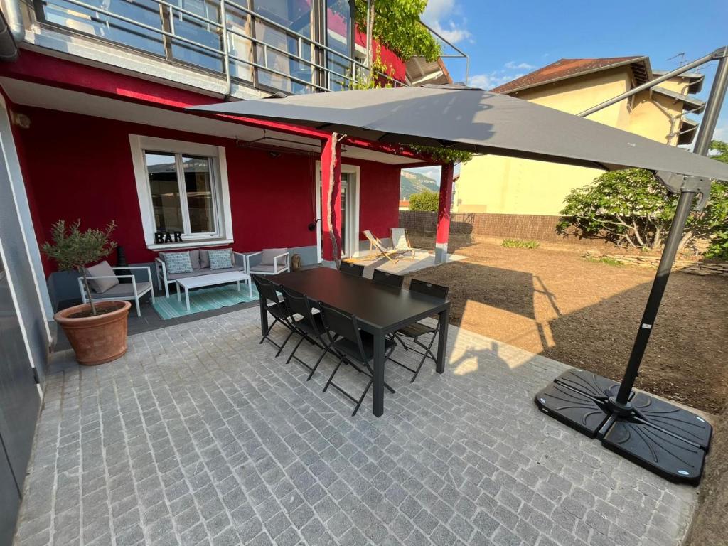 uma mesa preta com um guarda-chuva no pátio em Maison rouge em Millau