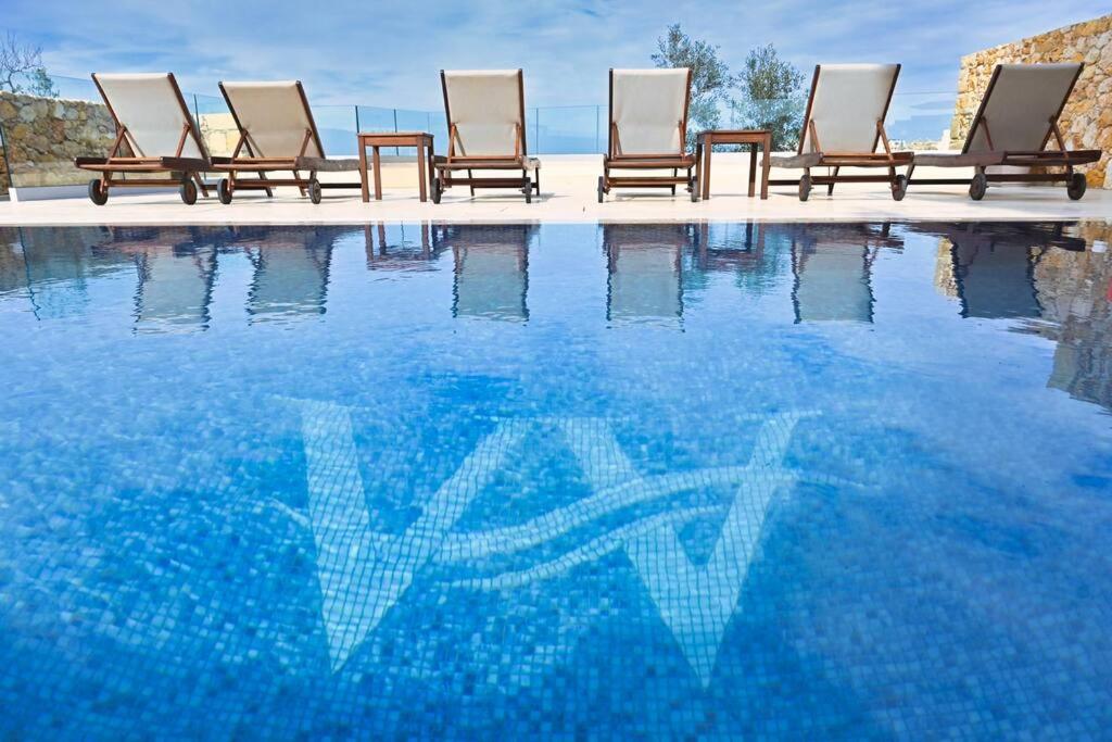 una fila de sillas sentadas junto a una piscina en Luxurious Maisonette with Pool, en Tal-Barmil