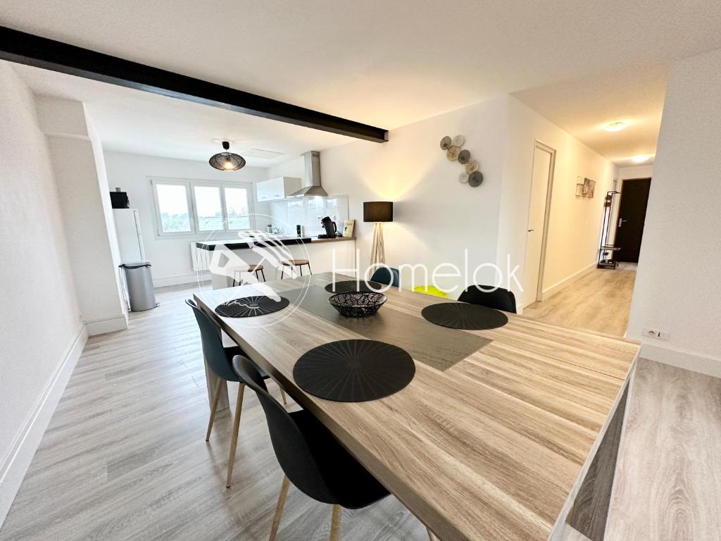 een eetkamer en een woonkamer met een tafel en stoelen bij Appartement T3 cosy – Entre bourg et plages in Ploemeur
