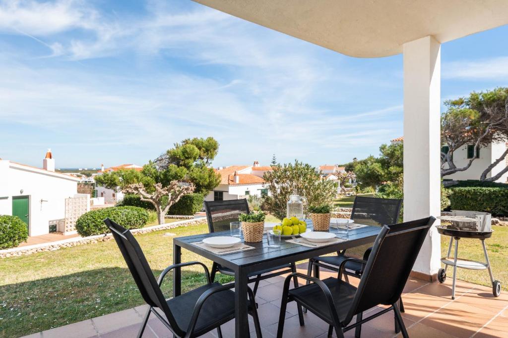 a patio with a table and chairs on a porch at Apartamento Can Harmonia - Arenal den Castell in Arenal d'en Castell