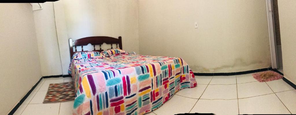 a bedroom with a bed with a colorful comforter at Aconchego em Parnaiba jw in Parnaíba