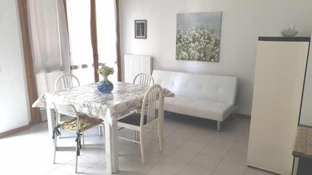 sala de estar con mesa, sillas y sofá en R07 Trilocale con terrazzo e garage, en Numana