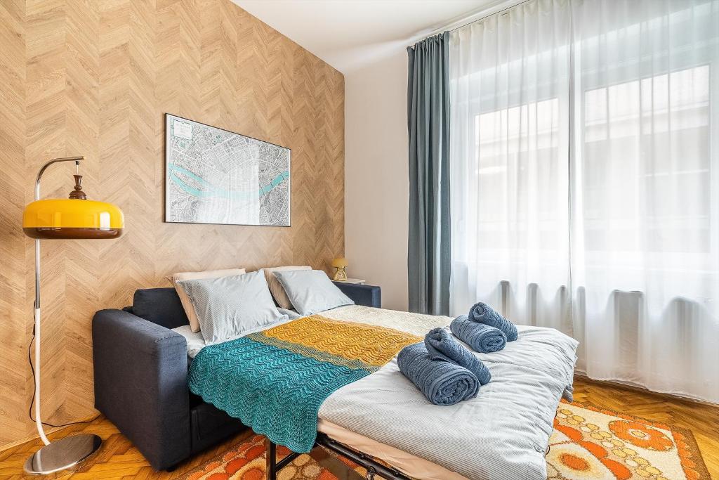 een slaapkamer met een bed met blauwe handdoeken bij Budapest Then & Now Apartment in Boedapest