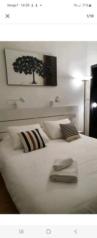 un lit blanc avec deux serviettes dessus dans l'établissement Chez lolo, à Vichy