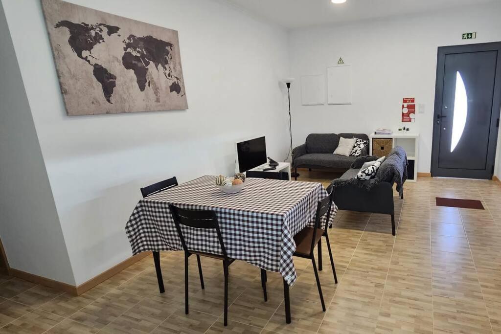 uma sala de estar com uma mesa e um sofá em Casa da Relva em Ponta Delgada