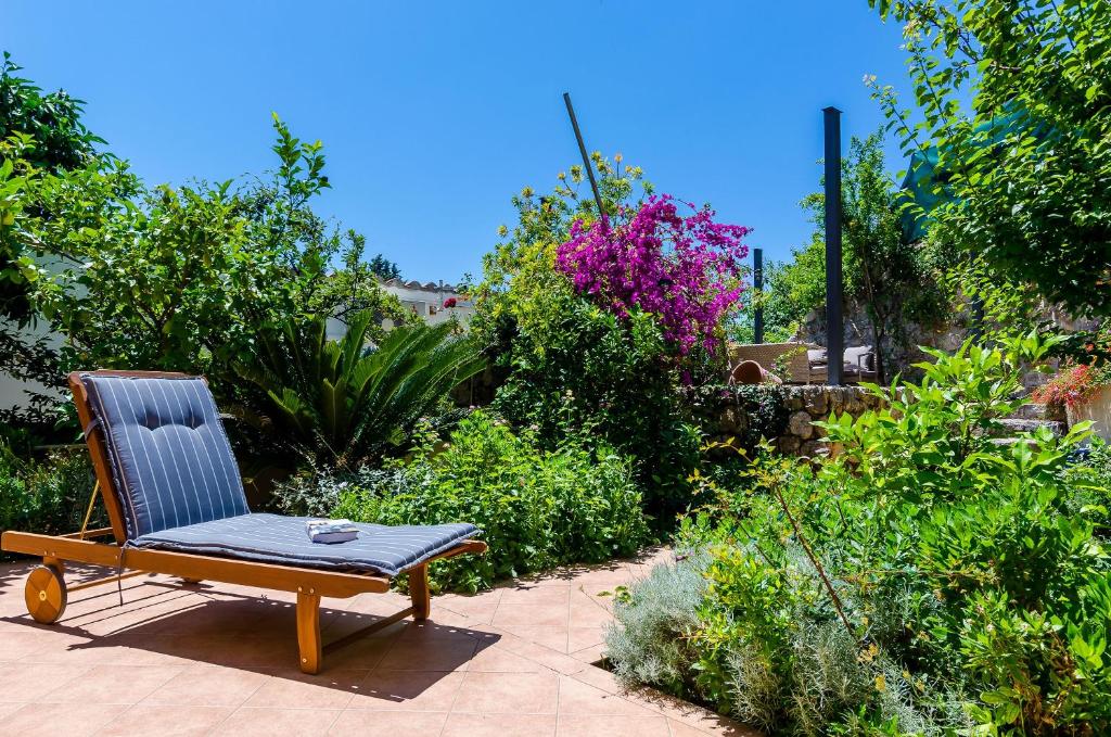 a chair sitting on a patio in a garden at Private Garden Apartment Dubrovnik in Dubrovnik