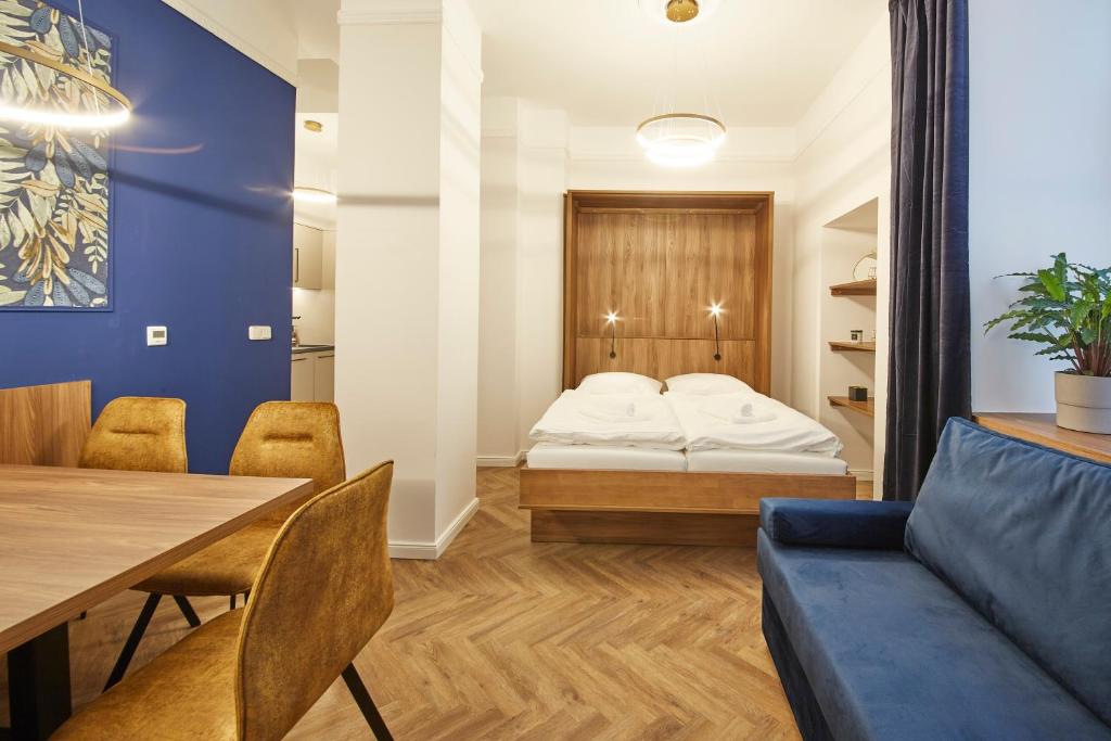 un soggiorno con letto, tavolo e sedie di Nove Boutique Apartments a Vienna