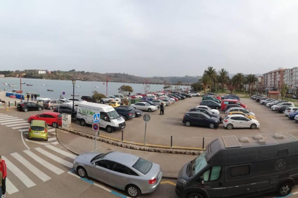 a parking lot full of cars parked next to the water at Piso Turístico Bahía San Vicente in San Vicente de la Barquera