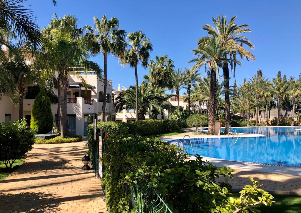 un complejo con piscina y palmeras en Medina de Banus Marbella, en Marbella