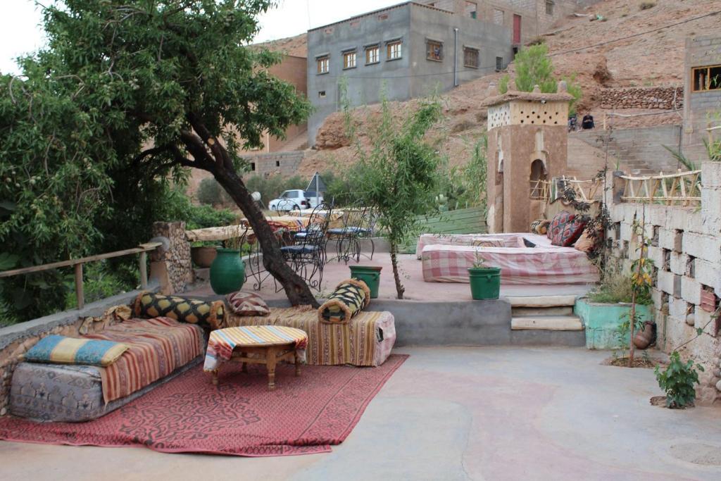 a patio with couches and tables and a building at Riad Les 5 Lunes in Aït Idaïr