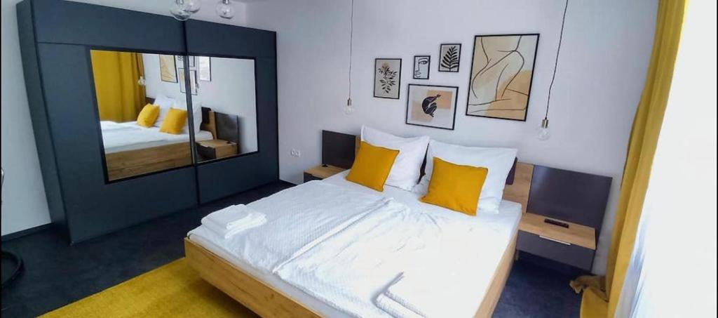 a bedroom with a bed with yellow pillows and a mirror at Penzion Ivka in Skalica