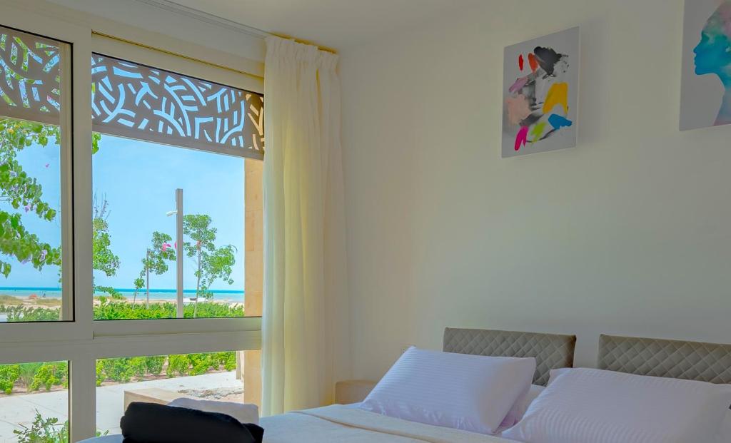 - une chambre avec un lit et une vue sur l'océan dans l'établissement Mangroovy Seaview 3BR Beach and Pool Free access, à Hurghada