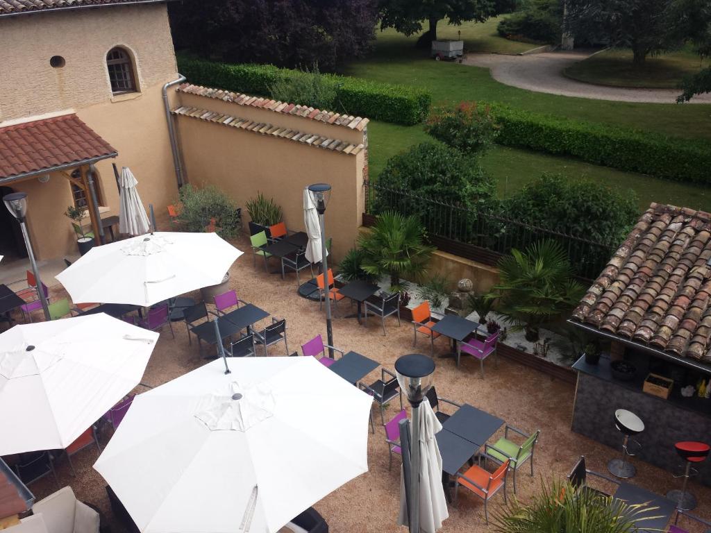 an overhead view of a patio with tables and umbrellas at Hôtel Carpe Diem in Savigneux