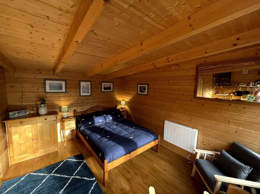 a bedroom with a bed in a wooden cabin at The Bee Hive Garden Room in Dorchester