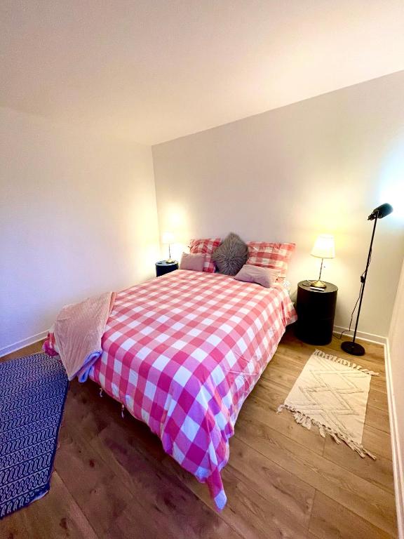 a bedroom with a bed with a checkered blanket at Appt vu sur un parc privatif à 20 min de Paris in Saint-Leu-la-Forêt