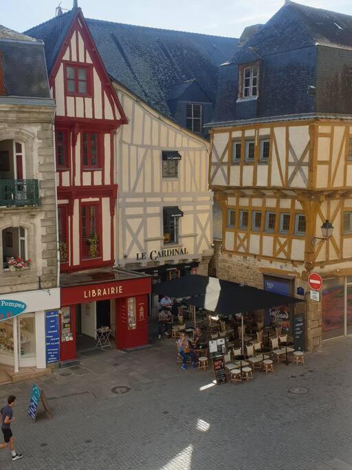 un groupe de bâtiments avec des tables et des chaises dans une rue dans l'établissement Appartement 4 personnes - Vannes intra-muros - Rue piétonne, à Vannes