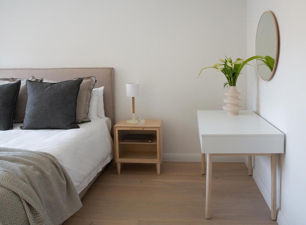 a bedroom with a bed and a table with a mirror at Neighbourgood Old Cape Quarter in Cape Town