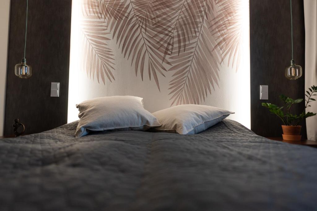 ein Schlafzimmer mit einem Bett mit zwei Kissen in der Unterkunft Tyylikäs City-huoneisto in Tampere