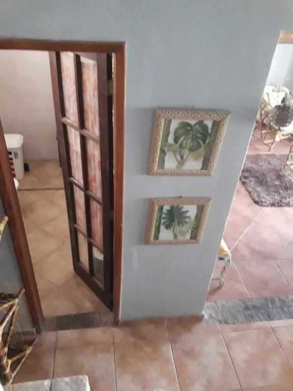 een kamer met twee foto's aan de muur en een deur bij Bedroom near Forest in Rio de Janeiro