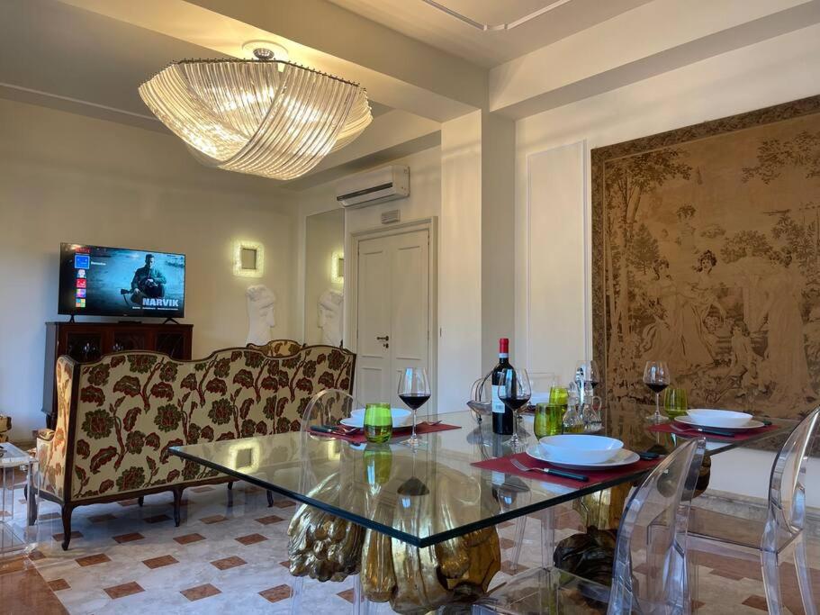 Una sala de estar con una mesa de cristal y un sofá. en Fancy House, en Reggio Calabria