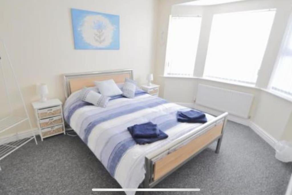 een slaapkamer met een groot bed met blauwe handdoeken bij Tivoli villas in New Brighton