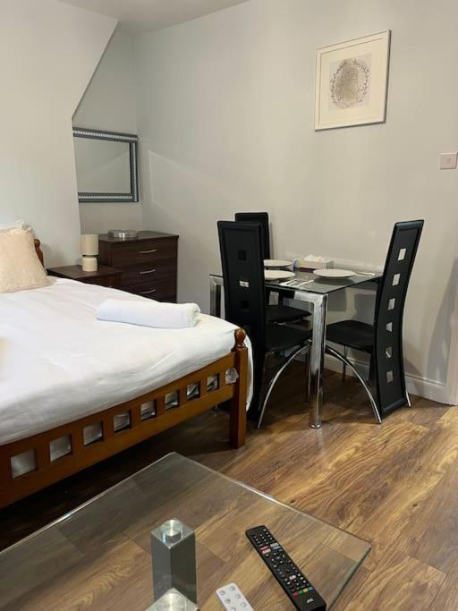 um quarto com uma cama, uma mesa e cadeiras em 008- S2Premium location studio apartment central London em Londres